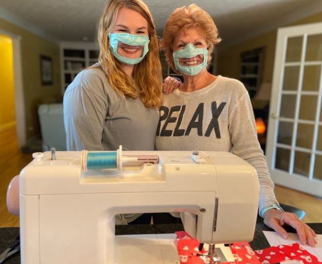 Na foto, Ashley Lawrence e sua mãe em frente a uma máquina de costura.